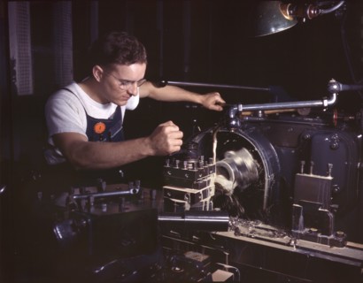 Worker in Machine Shop Finishing Aircraft Part on Huge Turret Lathe, North American Aviation, Inc., Inglewood, California, USA, Alfred T. Palmer for Office of War Information, October 1942