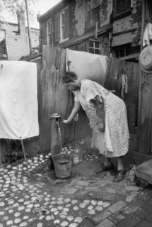 Woman Pumping Water in urban Backyard, Washington DC, USA, Carl Mydans for U.S. Resettlement Administration, July 1935