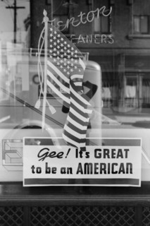 Man Standing near Store Window Sign, "Gee! It's Great to be an American", Covington, Kentucky, USA, John Vachon for Farm Security Administration, September 1939