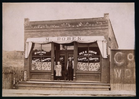 Girl, Dog and Man in Front of Store, 1900