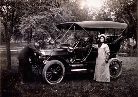 Woman Standing Beside Maxwell Touring Car and Driver Cranking Engine, USA, 1908