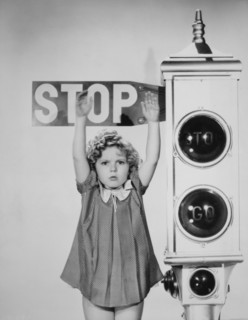 Shirley Temple, Holding Hands Up Against Stop Sign, Portrait, 1934