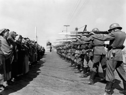 Row of German Soldiers with Rifles and Bayonets aimed at Norwegian Prisoners, on-set of the Film, "Edge of Darkness", 1943