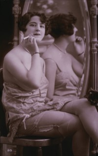 Lingerie Model Seated Beside Mirror Holding a Cigarette, circa 1920