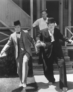 Stan Laurel and Oliver Hardy trying to Sneak Away from Producer Hal Roach, circa 1930's