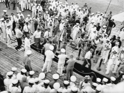 Astronauts Virgil "Gus" Grissom and John Young on Red Carpet on U.S.S. Intrepid on way to Debriefing after Completion of Gemini 3 Space Mission, 1965