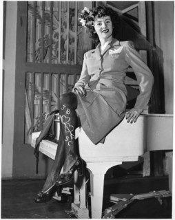 Woman in Skirt Wearing Dark Makeup on Legs (with additional romantic message) due to Shortage of Silk and Nylon Stockings during World War II, USA, 1943
