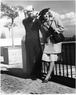 Actress K.T. Stevens Modeling Coat While Standing next to Pointing Sailor during World War II, 1944