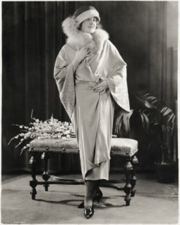 Fashionable Woman in Long Wrap-Dress of Canton Crepe with Fox Fur Collar and Embroidered Sleeves, with Hat, Portrait, circa 1923