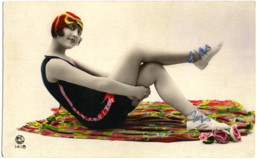 Seated Woman on Colorful Blanket Wearing Dark Swimsuit and Red Cap, Holding Thighs, Hand-Colored, French Postcard, circa early 1900's