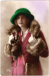 Fashionable Woman in Fur-Trimmed Coat and Green Hat Holding Binoculars, Hand-Colored Postcard, France, circa 1922