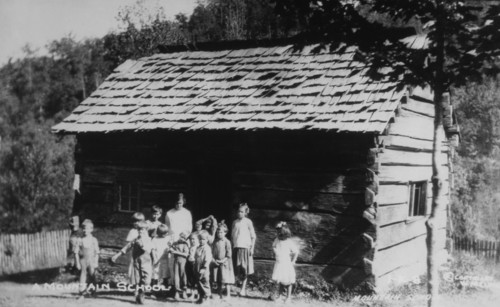Teacher and Students Standing in front of Log Cabin Mountain School, USA, circa 1910
