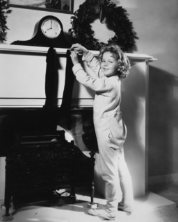 Shirley Temple, Publicity Portrait Hanging Christmas Stocking on Mantel, 1934