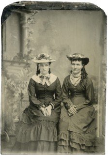 Portrait of Two Adult Women in Hats and Long Dresses, Both Seated with Hands Folded, Studio Shot, circa 1870