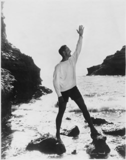 Actor Fredric March Standing with Raised Arm on Rocky Beach, California, USA, early 1940's