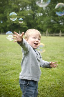 Happy Boy and Bubbles in Field