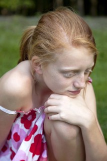 Young Girl Resting Chin on Knee Thinking