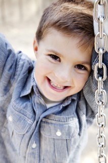 Smiling Boy on Tire Swing, Close Up