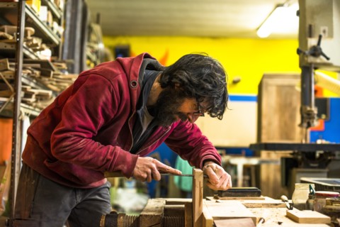 Woodworker Filing Dovetails in Piece of Wood
