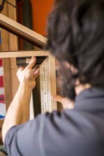 Woodworker Measuring a Shelf