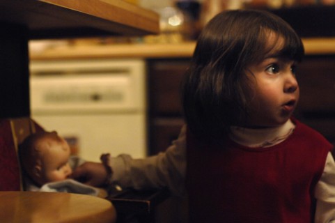 Little Girl with Baby Doll in Kitchen