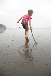 Young Girl Playing with Stick on Beach
