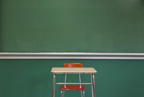 Empty Desk by Classroom Chalkboard