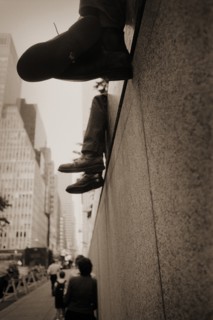 Legs and Shoes Dangling From Edge of Wall, New York City, USA