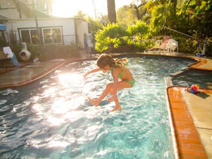 Young Girl Jumping in Pool