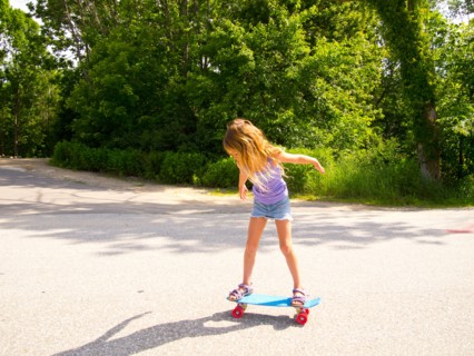 Young Girl Riding Skateboard in Street