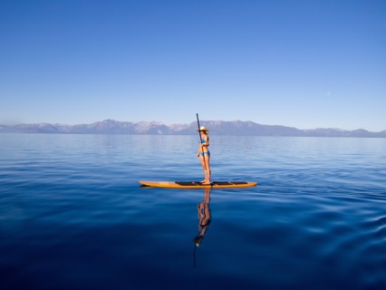 Woman Standing on Paddleboard Holding Paddle