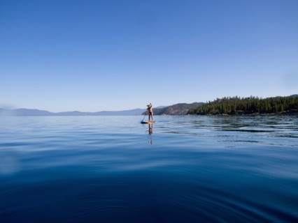 Woman Paddling on Lake in Distance