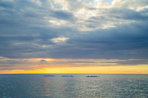 Three Outrigger Canoe Clubs Paddling at Sunset, Hawaii, USA