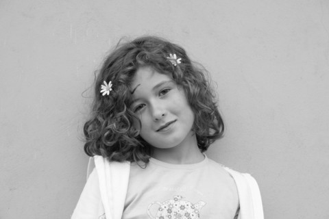 Smiling Young Girl with Two Flowers in Hair
