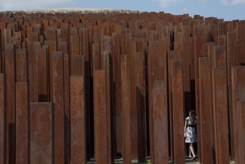Girl Standing Amongst Rusted Iron Pillars