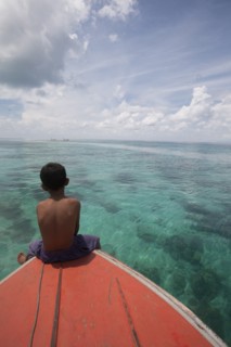 Young Boy Sitting at Front of Boat and Looking out to Sea, Borneo