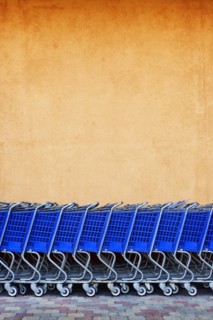 Line of Blue Shopping Carts Against Colorful Wall