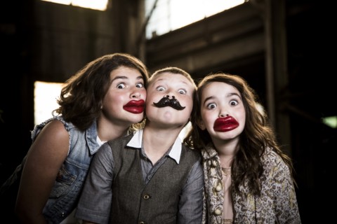 Two Wide-Eyed Girls and Boy Wearing Wax Lips and Making Silly Faces in Abandoned Warehouse