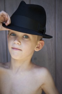 Young Boy Touching Brim of Fedora Hat