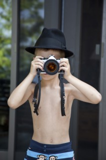 Young Boy Wearing Fedora Hat Taking Picture With Camera