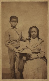 Full-length Portrait of an African American Boy Standing next to African American Girl, Seated with an Open Book, William A. Gladstone Collection of African American Photographs, late 1860's
