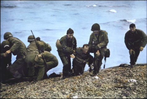 U.S. Soldiers of 116th Regiment of the 29th Infantry Division being helped to shore after Arriving at Omaha Beach in Life Raft after their Landing Craft Vehicle, Personnel (LCVP) had been Sunk off Bea...