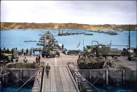U.S. Military Vehicles move ashore across Pontoon Bridge to Omaha Beach from Temporary Mulberry Harbour A, Normandy, France, June 16, 1944