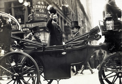 Theodore Roosevelt Standing in Carriage with his Hat Tipped while New York City Mayor William Gaynor and Cornelius Vanderbilt remain seated during his homecoming Reception after his trip abroad, New Y...