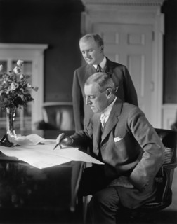 U.S. President Woodrow Wilson sitting at Desk in White House Oval Office with his Private Secretary Joseph Patrick Tumulty Standing nearby during Wilson's First Term in Office, Washington, D.C., USA, ...