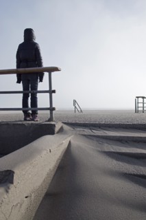 Rear View of Hooded Person Standing on Empty Beach