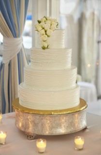Multi-Tiered Wedding Cake with White Roses Surrounded by Candles