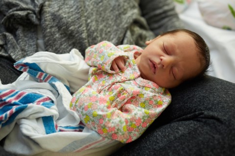 Newborn Baby Girl Sleeping in Mother's Lap in Hospital