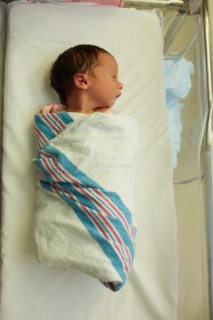 High Angle View of Sleeping Newborn Baby Girl Wrapped in Blanket in Hospital