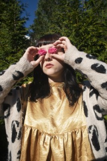 Half-Length Portrait of Young Adult Woman Holding Pink Roses to her Eyes
